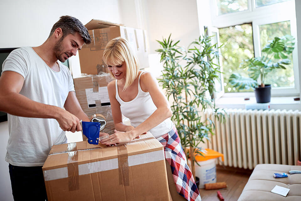 two friends packing their stuff after finding a moving company on a moving app