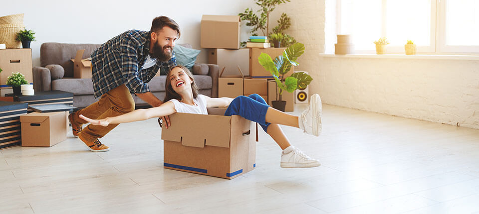 Man pushing a package with a girl sitting in it, after finding movers via an app to compare moving companies