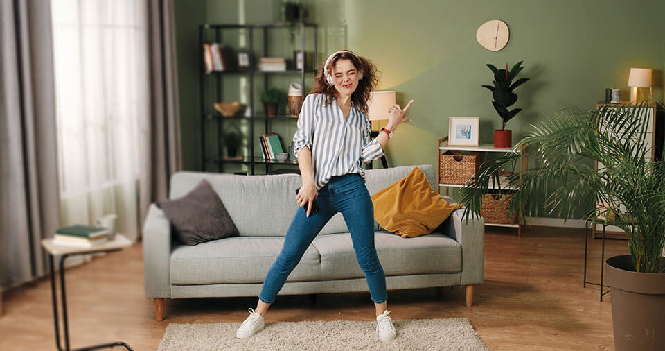 A woman dancing while listening to music on her headphones