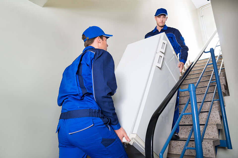 Moving company professionals carrying a refrigerator