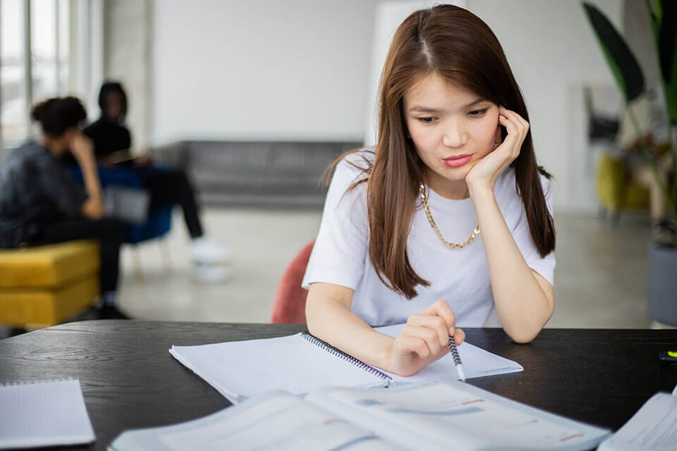 Thoughtful woman with a notebook thinking about moving companies