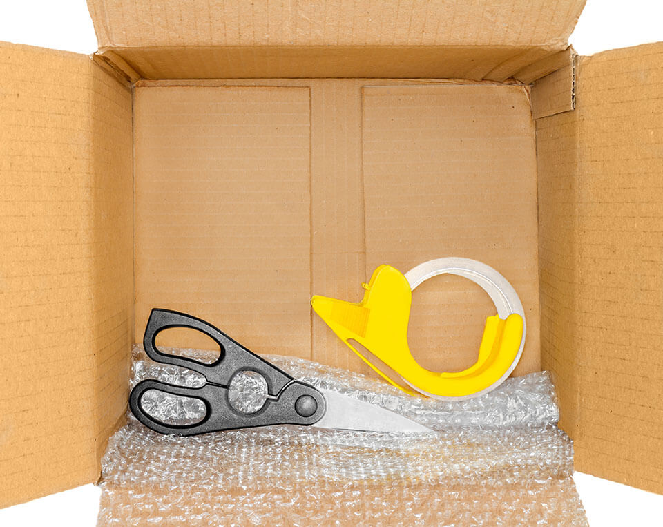 Tape, scissors, and bubble wrap in a box brought by a moving company
