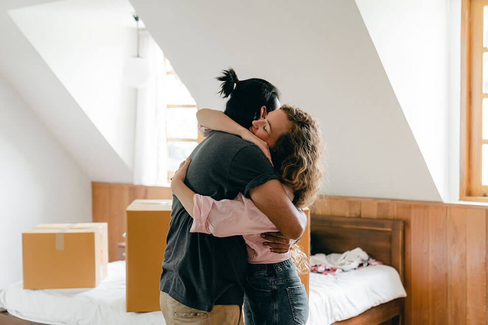 a couple hugging after relocating with a moving company