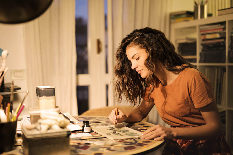 a young girl painting in her apartment