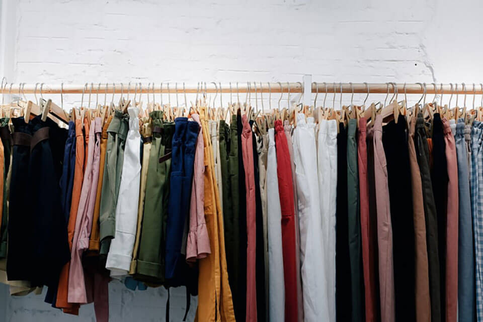 Jeans and shirts hanging on a rack