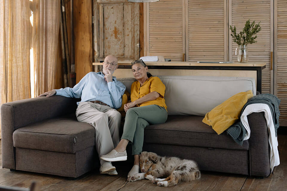 An older couple sitting on a sofa