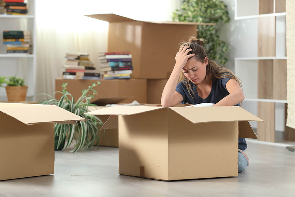 A girl holding her head and leaning on a box