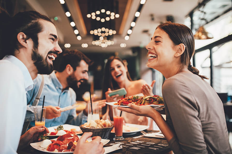 Two women and two men sitting in a restaurant and laughing